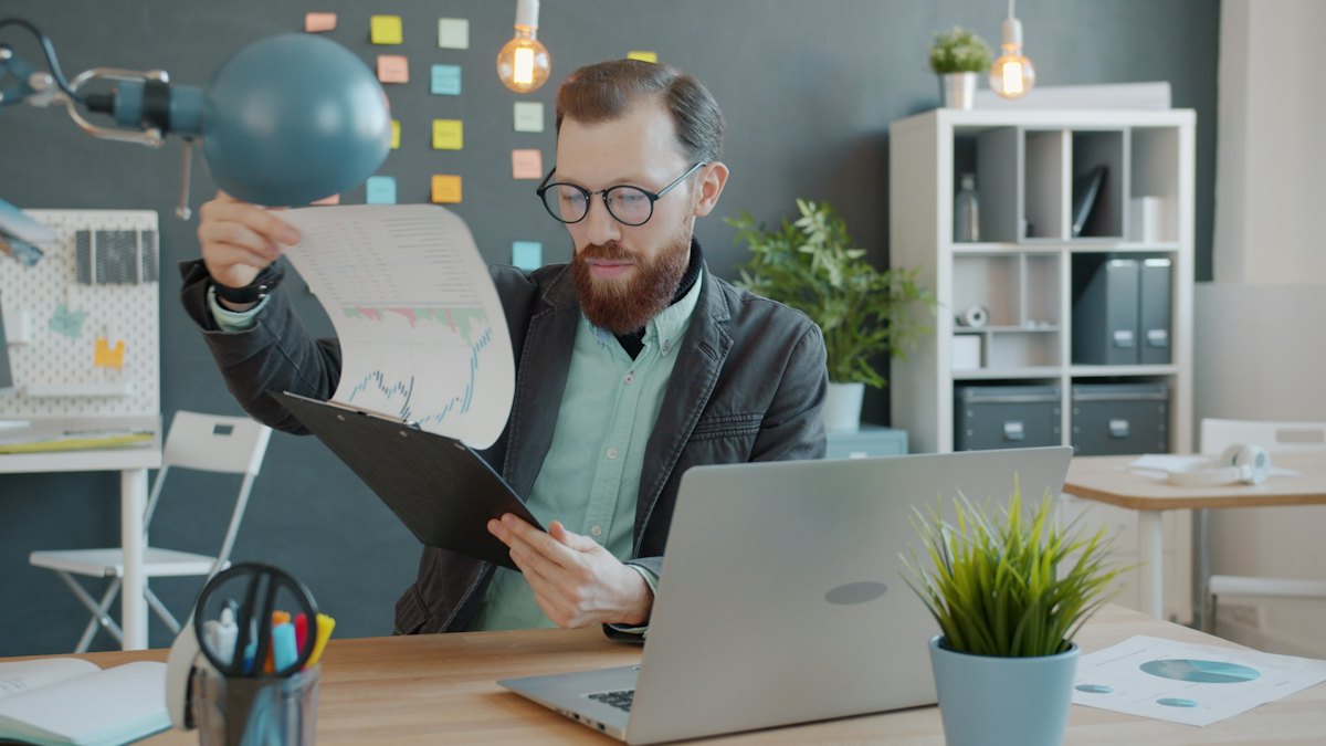 Man comparing printed drafts at his desk